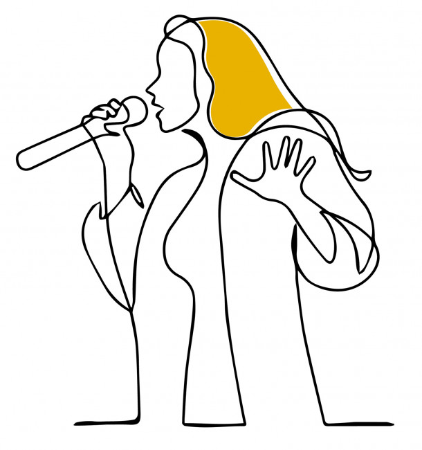 long haired person singing into a microphone